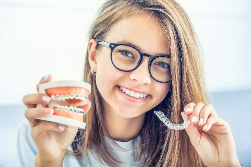 Young smiling girl demonstrating Invisalign orthodontic treatment in Charles Town, WV